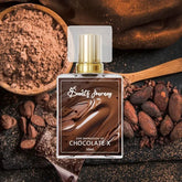 Chocolate perfume bottle with gold cap surrounded by cocoa powder, cacao beans, and chocolate pieces